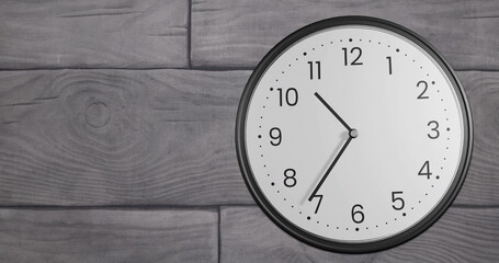 Image of clock ticking over grey tiled background