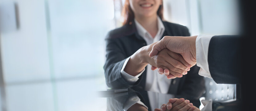 Business handshake. Business people making a handshake, close up. Two corporate businessman shaking hands during meeting in office