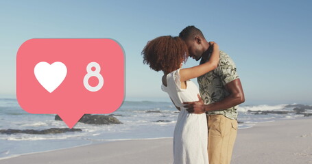 Heart icon with increasing numbers against african american couple embracing each other on the beach