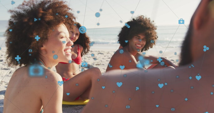 Image of network of digital icons over friends on beach