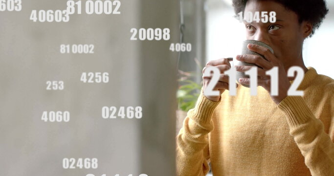 Image of numbers and data processing over african american man with tea in office