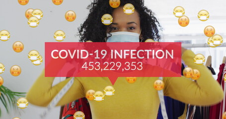 Image of words covid-19 infection and emoji floating with woman wearing face mask