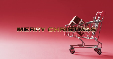 A miniature shopping cart contains a gift, symbolizing holiday shopping