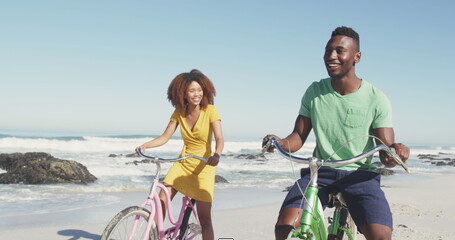 Image of speech bubbles with lol text over happy couple riding bikes on beach