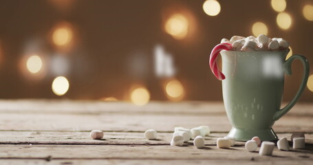 A cozy mug of hot chocolate adorned with marshmallows on a wooden table