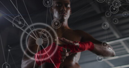 Fototapeta premium Image of network of connections over man tying ribbons on his hands