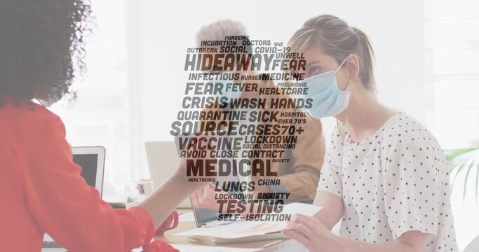 Image of words floating with colleagues in office wearing face masks