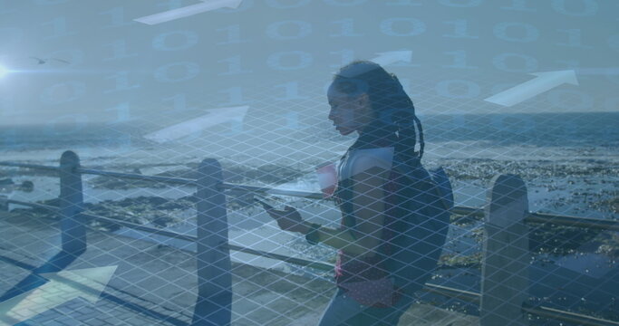 Image of binary data processing over woman walking with smartphone, exercising by seaside - Powered by Adobe