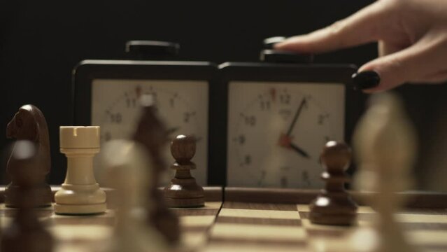 Player takes turns moving chess pieces on the board and presses the clock button to stop the time