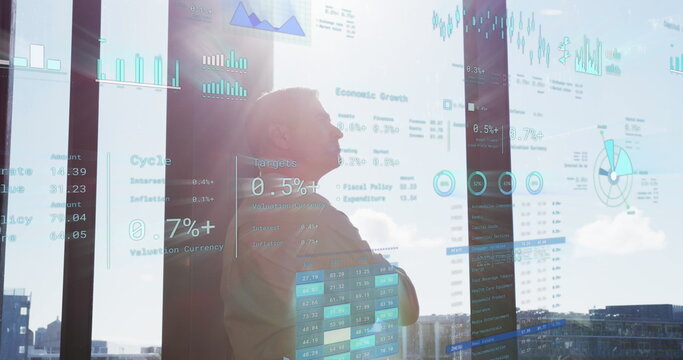 Image of financial data with icons over caucasian businessman in office