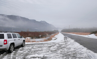 Looking down Rannie Road leading to the Grant Narrows Regional Park and Pitt River Dike during a snowy winter season in Pitt Meadows, British Columbia, Canada