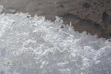 Crackled ice next to clear frozen water background