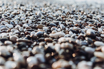 background of pebbles on the sea. Mediterranean coastal area. small sea stones. pebbles close up. photo of stones with bokeh effect