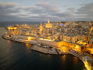 wilight over Valletta: Aerial View of the Historic City Skyline with Illuminated St. Paul's Pro-Cathedral and the Grand Harbour - Malta