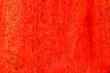 Red metal surface with spots creating textured wall background