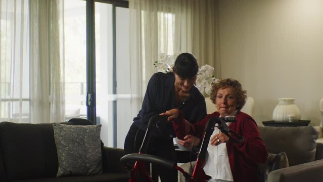 Old woman and her asian caretaker in the retirement home helping her