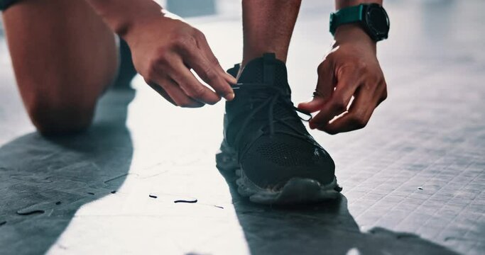 Closeup, gym or hands of person with shoes for training, exercise or workout routine in fitness center. Lace, tie or legs of sports athlete with footwear ready to start practice on studio floor alone