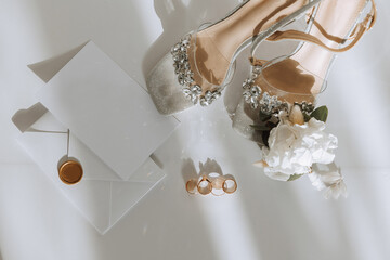 Bride's engagement ring, stilettos, Perfume. Wedding details of the bride. Flowers Beautiful light. wedding dress