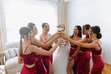 Photo bride with her friends drinking champagne from glasses. Cropped shot of a beautiful young...