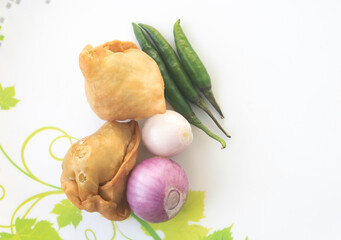 A samosa is a deep-fried pastry from South Asia that is filled with savory ingredients including peas, pork, fish, onions, or spicy potatoes. Also called Shingara.