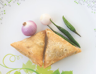 A samosa is a deep-fried pastry from South Asia that is filled with savory ingredients including peas, pork, fish, onions, or spicy potatoes. Also called Shingara.