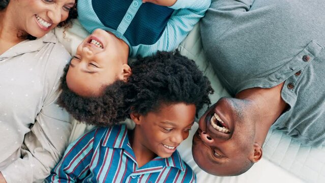 Morning, laugh and happy family on bed for bonding, love and care in home from above. Mom, dad and kids in bedroom, excited and spending time together on weekend for fun, support and relax in house.