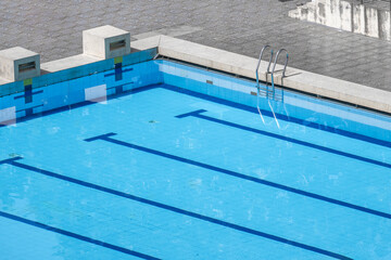 Top view swimming pool outlined by bold lanes, inviting swimmers to glide through clear turquoise...