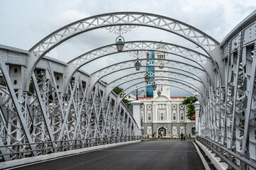 Anderson Bridge spans Singapore River in view captured from bridge itself. photo showcases elegant architecture, offering glimpse cityscape and river life