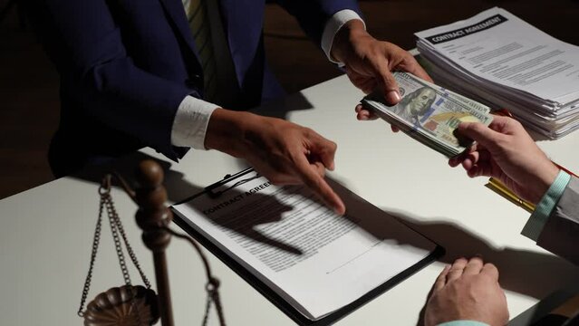 The lawyer taking a dollar bribe from a male client for falsifying documents, a businessman taking bribes corruption illegal fraud bribery concept.