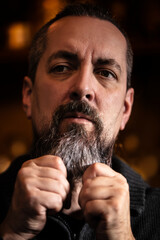 Handsome bearded man is styling the beard, morning routine and face care