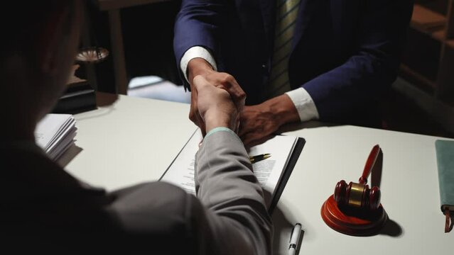 Lawyers shake hands with business people to seal a deal with partner lawyers. or a lawyer discussing contract agreements, handshake concepts, and agreements.