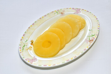 Pineapple lies in circles on a plate.