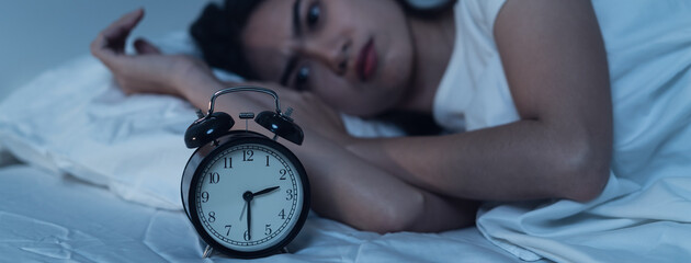 Close-up alarm Young Asian woman have insomnia on the bed