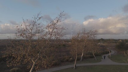 Drone footage of nature landscape with town cityscape view in the background under blue cloudy sky
