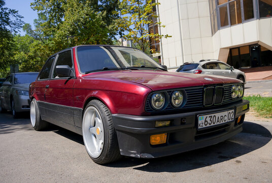 Almaty, Kazakhstan - August 25, 2023: The front of an old BMW 3 Series coupe is burgundy
