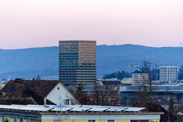 Obraz premium View with skyline and skyscraper with mountain in the background on a beautiful sunrise at Swiss City of Zürich on a sunny winter morning. Photo taken January 27th, 2024, Zurich, Switzerland.
