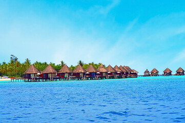 Water villas stand abreast in Maldivian sea 5