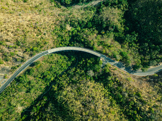 aerial top view above Huai Tong Bridge.. Forest River Bridge under a Blue Sky with Green Landscape and Mountain Views, .featuring Trees