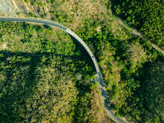aerial top view above Huai Tong Bridge.. Forest River Bridge under a Blue Sky with Green Landscape and Mountain Views, .featuring Trees
