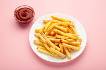 French fries with ketchup in bowl on pink background
