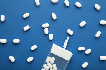 Tasty mint dragee candies with box on blue background