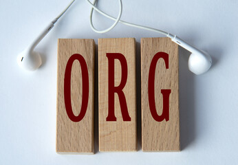 ORG - acronym on wooden blocks on white background with wired headphones