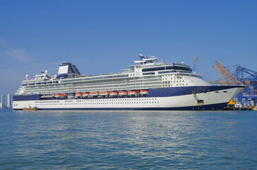 Cruiseship cruise ship liner Infinity in port with harbor infrastructure moored to pier