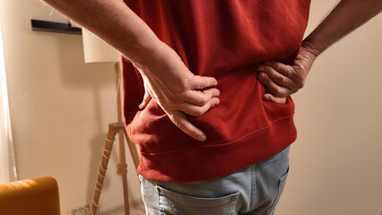 Man with hip, back and sciatica pain at home.