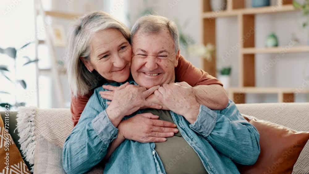 Wall mural Happy, love and senior couple hug on a sofa with kiss, comfort and bonding at home together. Marriage, support and old people embrace in a living room with trust, respect and gratitude, smile or care