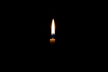 white burning candle on a black background
