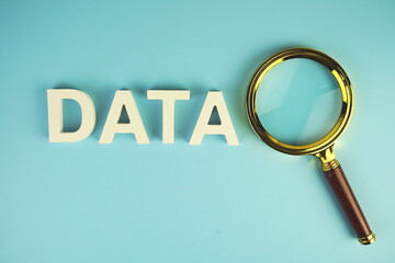 Data alphabet letters with magnifying glass on blue background