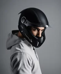 Gardinen portrait of a man in a black coloured motorcycle helmet, isolated grey background  © abu