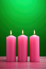 exquisite pink shaped lighted candles. . green background. free space