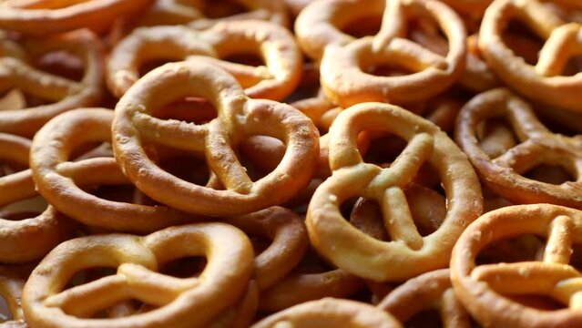 Crunchy German pretzel cracker cookies with salt crystals circle rotation close up
